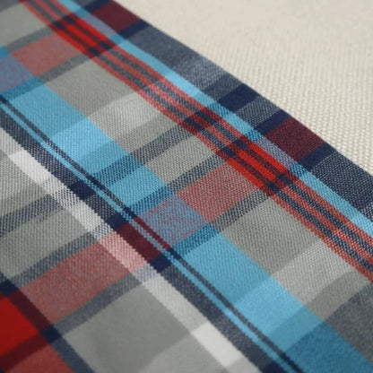Primer plano del tejido de algodón con estampado de cuadros en azul celeste, gris y líneas rojas de una camisa Dubrovnik