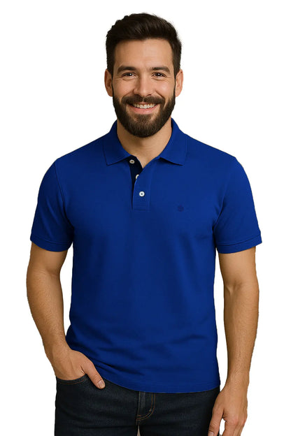 Hombre con barba sonriendo con un polo de manga corta en color azul rey vibrante, con contraste azul marino en la carterita del cuello y logotipo bordado, de la marca Dubrovnik