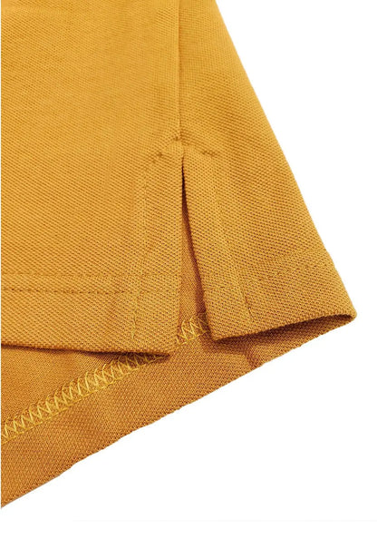 Primer plano del acabado inferior de un polo Dubrovnik color mostaza, resaltando la aletilla lateral con refuerzo de costura y la textura del piqué 50/50