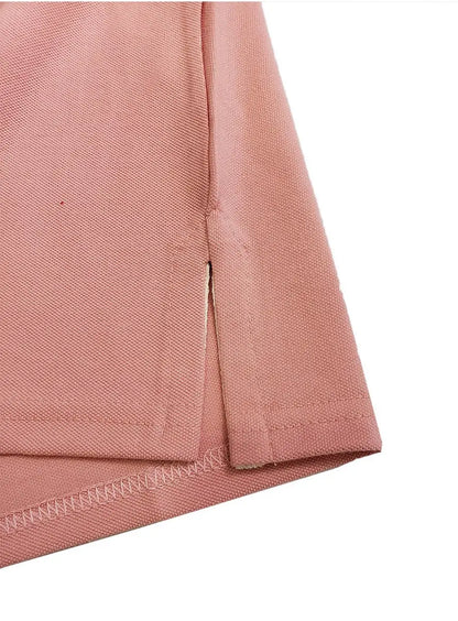 Primer plano del detalle de la costura y abertura lateral de un polo infantil en color rosa pastel, mostrando el acabado de la prenda y la textura del tejido piqué de la marca Dubrovnik