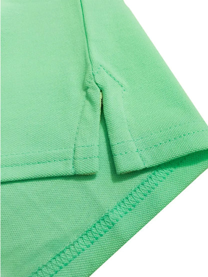 Primer plano del detalle de la costura y abertura lateral de un polo infantil en color verde menta, resaltando la textura del tejido piqué y la calidad del acabado de Dubrovnik