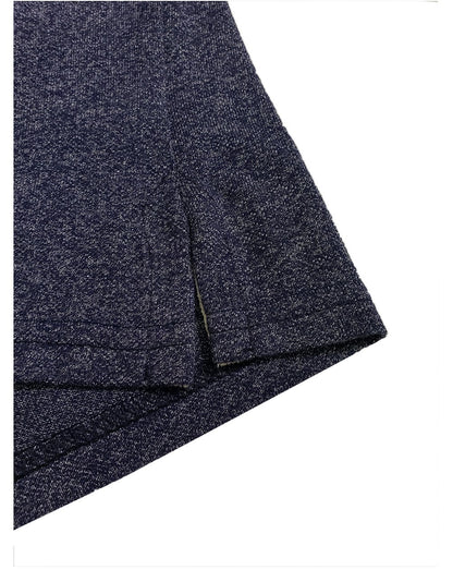 Primer plano del acabado inferior de un polo Dubrovnik azul marino jaspeado, mostrando la abertura lateral con refuerzo interno en tono crema y doble costura