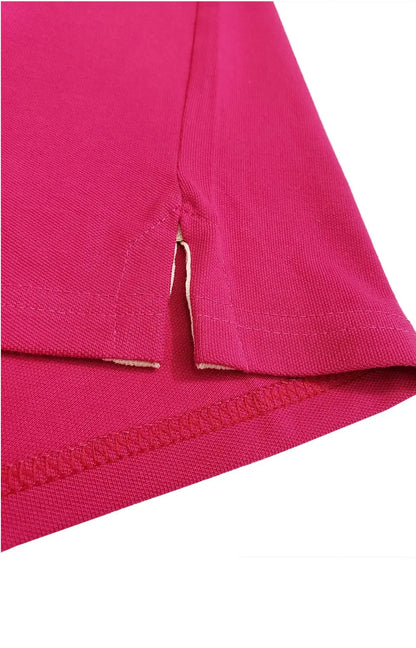 Primer plano del acabado inferior de un polo Dubrovnik color fucsia, resaltando la abertura lateral con refuerzo interno en color crema y doble costura de seguridad