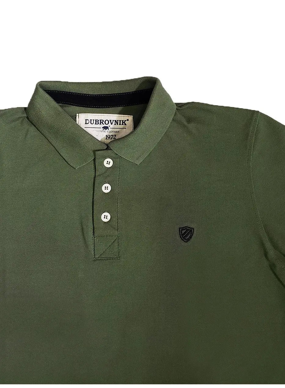 Primer plano de polo Dubrovnik color verde oliva mostrando el contraste azul marino en el cuello interno, botones blancos reforzados y el escudo bordado con precisión técnica