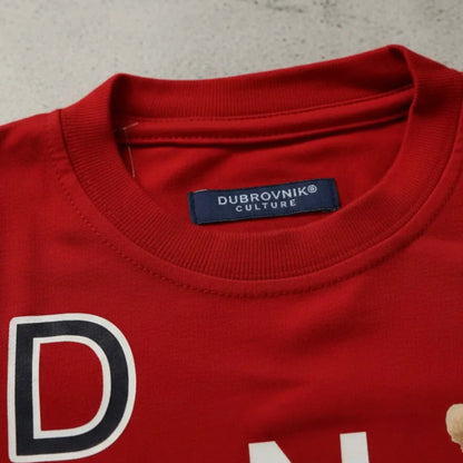 Primer plano del cuello de una camiseta roja con etiqueta azul marino "Dubrovnik Culture" y detalle de estampado blanco