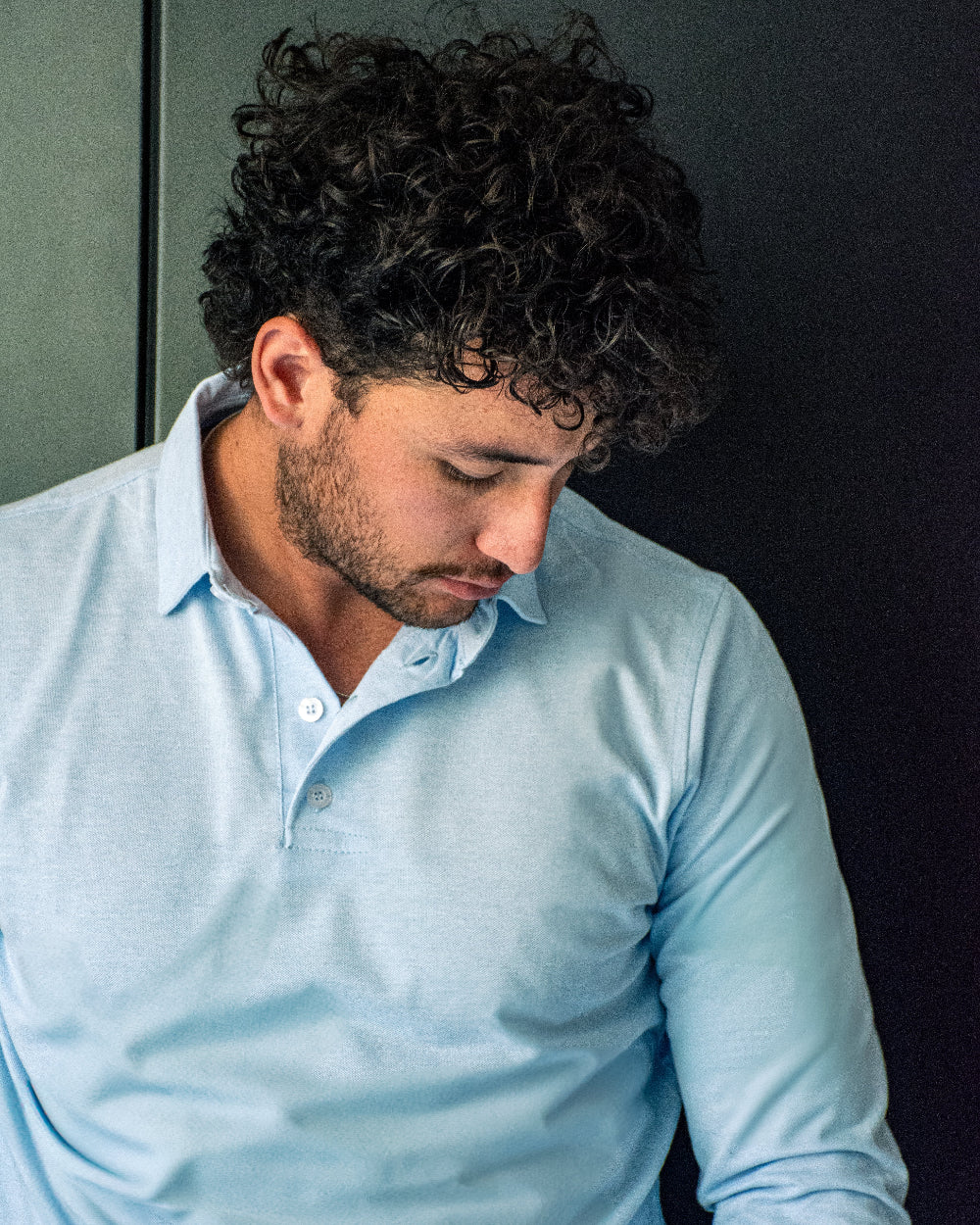 Primer plano del cuello y botones de un polo de manga larga azul marino para hombre con etiqueta roja de Dubrovnik