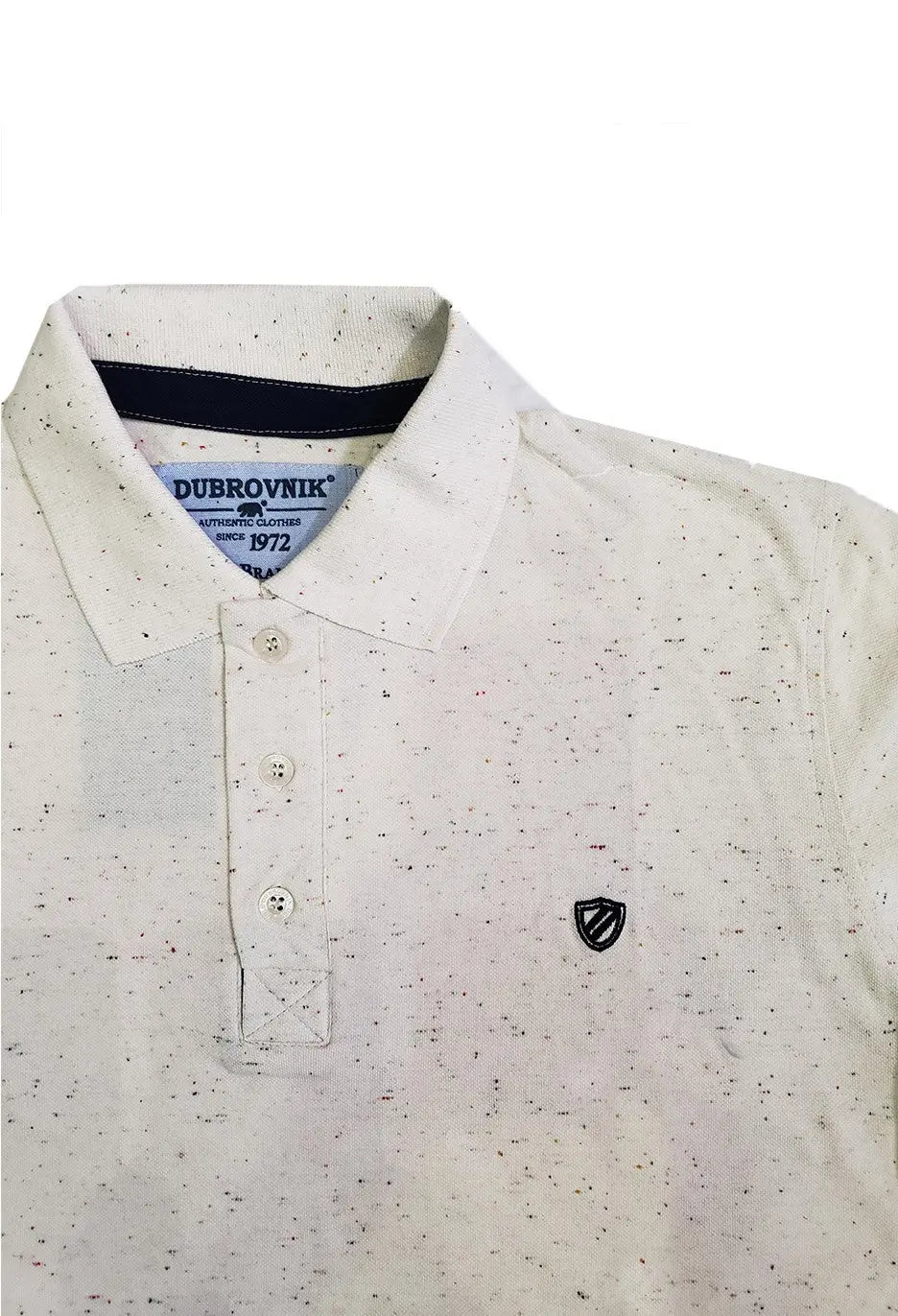 Primer plano de polo Dubrovnik beige con efecto jaspeado multicolor, destacando la cinta interna en azul marino, botones perlados y el escudo bordado en contraste