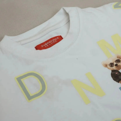 Primer plano del cuello de una camiseta blanca con etiqueta roja de la marca Dubrovnik Club y gráficos amarillos