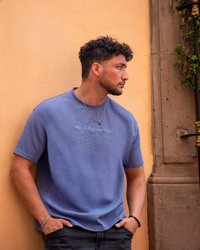 Plano posterior de una camiseta verde militar con un gran gráfico blanco que incluye pájaros en ramas, flores, caracteres japoneses y el texto TOKYO By Dubrovnik