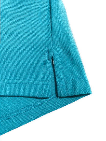 Primer plano del acabado inferior de un polo Dubrovnik color azul turquesa, mostrando la apertura lateral reforzada y la textura del tejido piqué premium