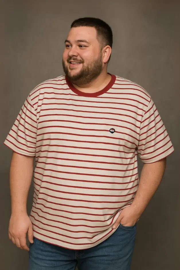 Hombre con barba sonriendo de perfil vistiendo una playera blanca de cuello redondo con diseño de rayas horizontales delgadas en color granate, de la colección Dubrovnik Tallas Extras