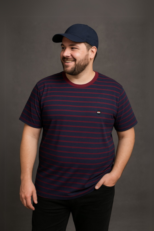Hombre con barba y gorra azul marino vistiendo una playera de cuello redondo con diseño de rayas horizontales en azul marino y granate, de la colección Tallas Extras de Dubrovnik
