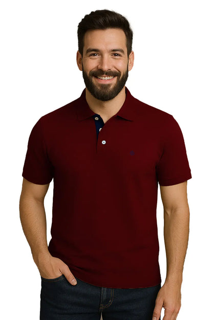 Hombre con barba sonriendo con un polo de manga corta en color guinda profundo, con contraste azul marino en la carterita interna del cuello y escudo bordado, de la marca Dubrovnik