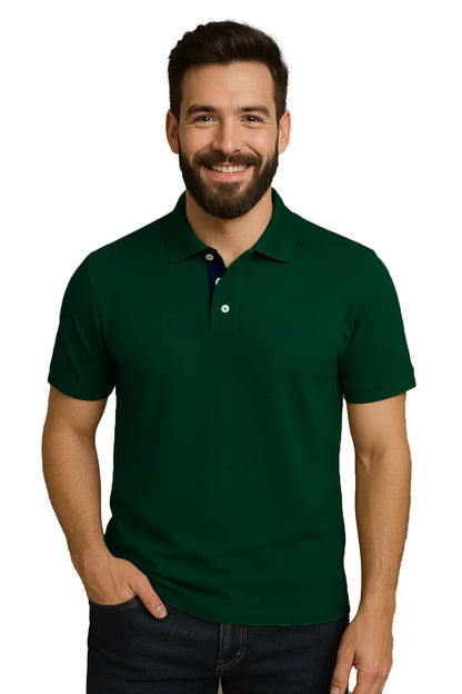 Hombre con barba sonriendo con un polo de manga corta en color verde bosque profundo, con detalle de carterita interna en azul marino y escudo bordado discreto, de la marca Dubrovnik