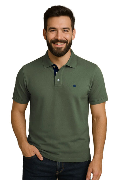 Hombre con barba sonriendo con un polo de manga corta en color verde musgo, con contraste azul marino en la carterita interna del cuello y escudo bordado, de la marca Dubrovnik