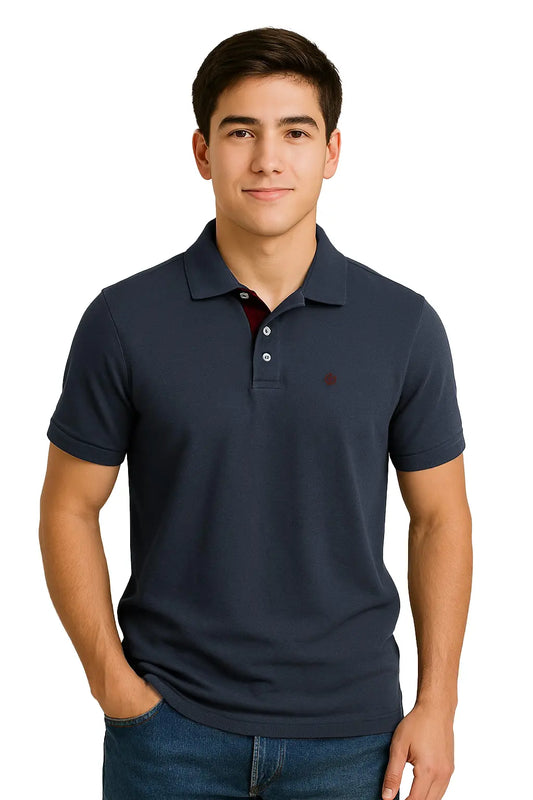 Modelo joven con polo Dubrovnik color azul petróleo de corte regular, resaltando el detalle de la carterita interna en color vino y logotipo bordado circular