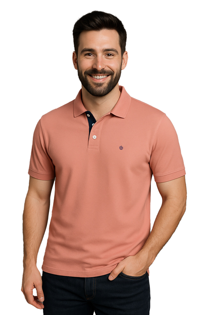 Modelo sonriendo con polo Dubrovnik color salmón de corte regular, resaltando el detalle de la carterita interna en azul marino y logotipo bordado en el pecho