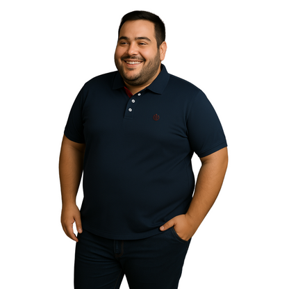 Hombre de complexión robusta sonriendo con polo Dubrovnik azul marino en corte para tallas extras, destacando el contraste tinto en el cuello interno y logotipo bordado