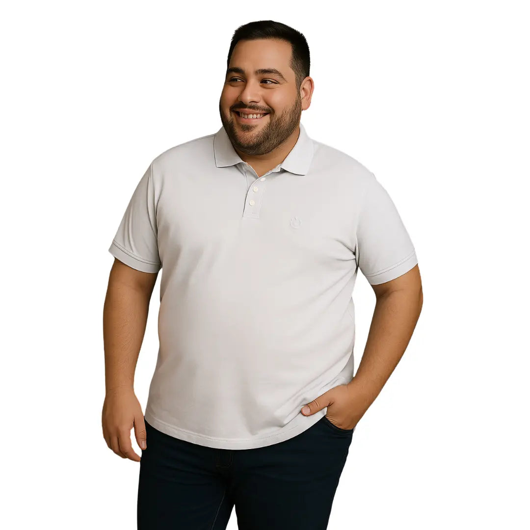 Hombre de complexión robusta sonriendo con polo Dubrovnik blanco en talla extra, mostrando el ajuste cómodo y el bordado sutil a tono en el pecho