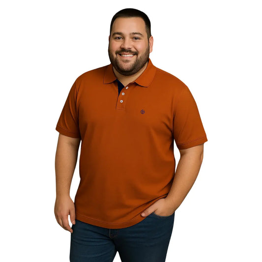 Modelo de complexión robusta sonriendo con polo Dubrovnik color teja en talla extra, con detalle de carterita interna en azul marino y logotipo bordado a tono