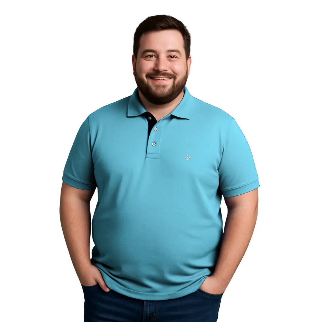 Hombre de complexión robusta sonriendo con un polo de manga corta en color azul turquesa vibrante, con contraste interno azul marino en el cuello y logotipo bordado, de la marca Dubrovnik