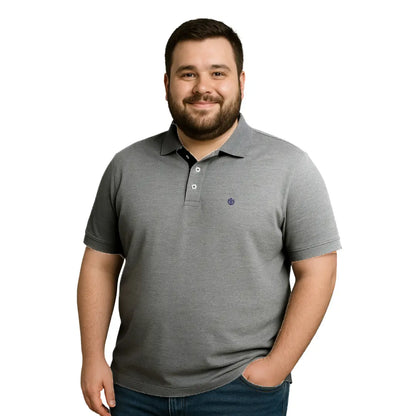 Modelo de complexión robusta con polo Dubrovnik gris oxford en talla extra, resaltando el detalle de carterita interna en negro y el escudo circular bordado