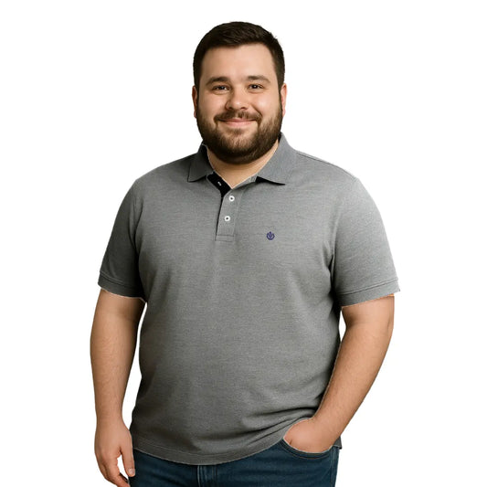 Modelo de complexión robusta con polo Dubrovnik gris oxford en talla extra, resaltando el detalle de carterita interna en negro y el escudo circular bordado