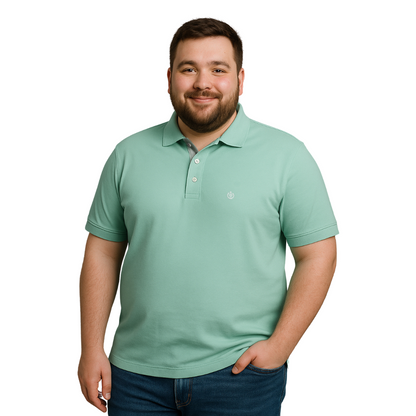Hombre de complexión robusta sonriendo con polo Dubrovnik verde menta en corte para tallas extras, resaltando el detalle gris en la carterita interna y el ajuste cómodo