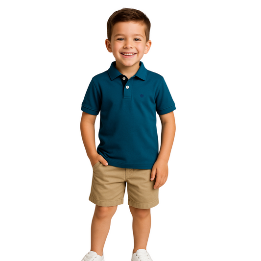 Niño posando con un polo de manga corta en color azul petróleo con detalles oscuros en el cuello, combinado con bermudas color beige, de la colección infantil de Dubrovnik